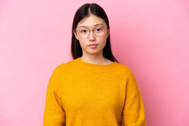 Young Chinese woman isolated on pink background With glasses