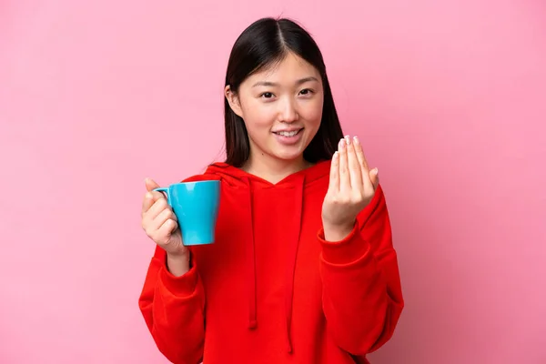Young Chinese Woman Holding Cup Coffee Isolated Pink Background Inviting — Φωτογραφία Αρχείου