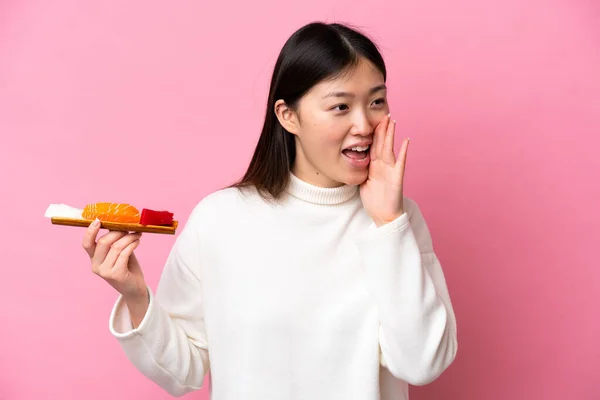 Young Chinese Woman Holding Sashimi Isolated Pink Background Shouting Mouth — стоковое фото