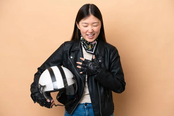 年轻的中国女人戴着摩托车头盔 带着米黄色的背景 面带微笑 — 图库照片