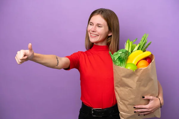 Young English Woman Holding Grocery Shopping Bag Isolated Purple Background — стоковое фото