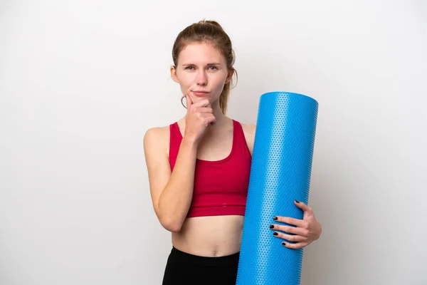 年轻的英国女运动员一边去上瑜伽课 一边拿着一块用白色背景思维隔开的垫子 — 图库照片