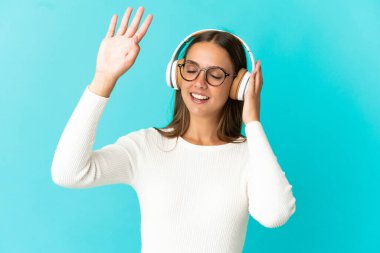Soyutlanmış mavi arka plan müzik ve dans dinleyen genç bir kadın.