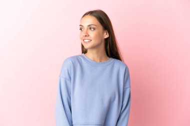 Soyutlanmış pembe arka planda genç bir kadın.