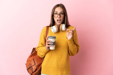 Soyutlanmış pembe arka planı olan genç bir bayan parmağını kaldırarak çözümü bulmaya çalışıyor.