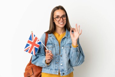 Young hispanic woman holding an United Kingdom flag over isolated white background showing ok sign with fingers