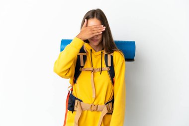 Young mountaineer woman with a big backpack over isolated white background covering eyes by hands. Do not want to see something