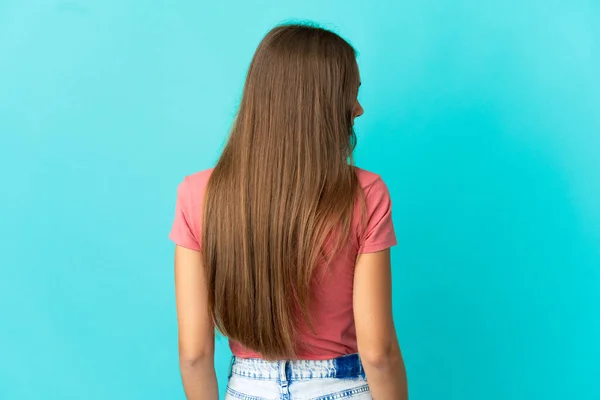 Junge Frau Vor Isoliertem Blauen Hintergrund Rückenlage Und Seitlich Schauend — Stockfoto