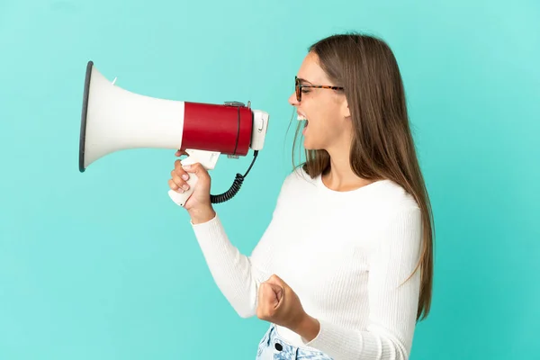 Jonge Vrouw Geïsoleerde Blauwe Achtergrond Schreeuwt Door Een Megafoon Iets — Stockfoto