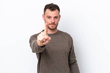 Beyaz arka planda izole edilmiş genç Brezilyalı adam parmağını kaldırıyor ve gösteriyor.