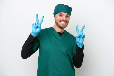 Cerrah Brezilyalı yeşil üniformalı adam beyaz arka planda izole edilmiş zafer işaretini iki eliyle gösteriyor