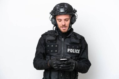 Brezilyalı asker beyaz arka planda izole edilmiş olarak cep telefonuyla mesaj gönderiyor.