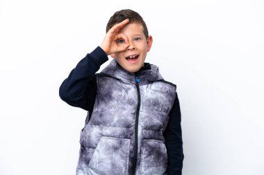 Beyaz arka planda izole edilmiş küçük çocuk parmaklarıyla tamam işareti gösteriyor.