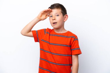 Beyaz arka planda izole edilmiş küçük bir çocuk ön tarafa bakarken sürpriz jest yapıyor.