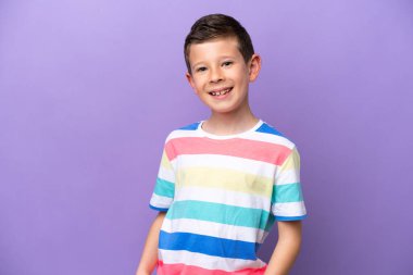 Küçük çocuk mor arka planda yalnız gülüyor.