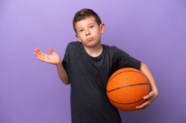 Little boy playing basketball isolated on purple background having doubts while raising hands