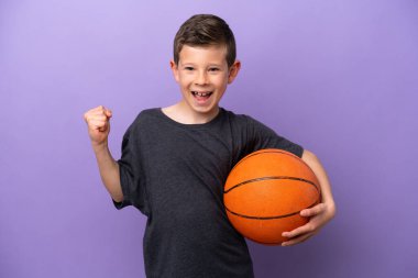 Mor arka planda basketbol oynayan küçük çocuk zaferi kutluyor.
