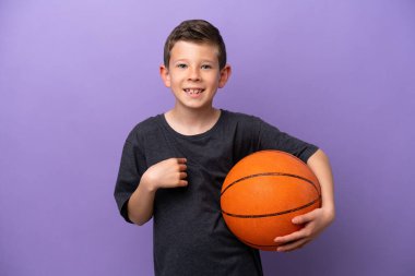 Mor arka planda basketbol oynayan küçük çocuk şaşırmış yüz ifadesi ile izole edilmiş.
