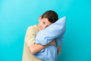 Mavi arka planda pijamalı küçük bir çocuk.