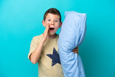 Mavi arka planda, ağzı açık bağıran pijamalı küçük bir çocuk.