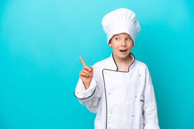 Küçük aşçı çocuk mavi arka planda izole edilmiş bir şekilde parmağını kaldırarak çözümü bulmaya çalışıyor.