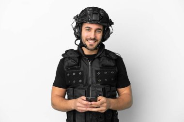 Beyaz arka planda izole genç Kafkas SWAT cep telefonu ile bir mesaj gönderiyor