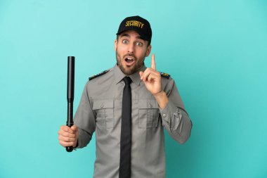 Genç güvenlik görevlisi mavi arka planda izole edildi. Çözümü bulmak için parmağını kaldırdı.