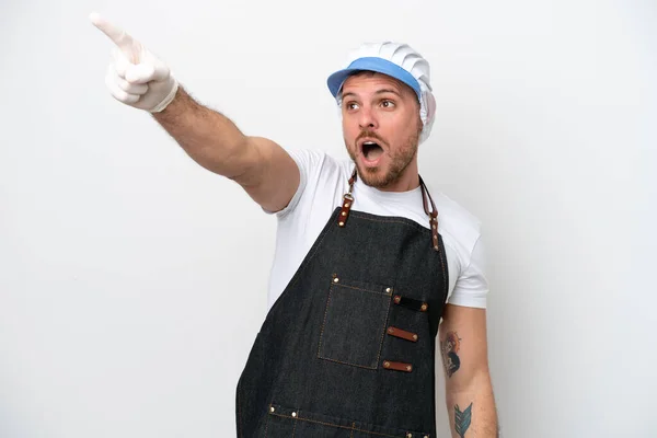 Fishmonger man wearing an apron isolated on white background pointing away