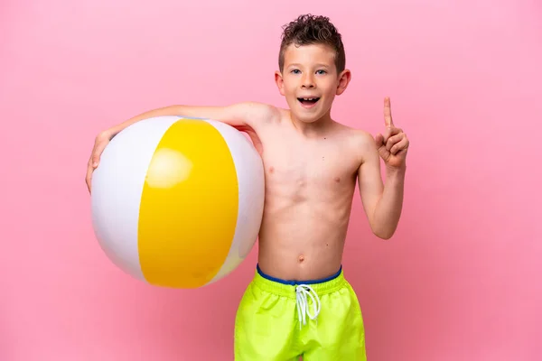 Little Caucasian Boy Holding Beach Ball Isolated Pink Background Pointing —  Fotos de Stock