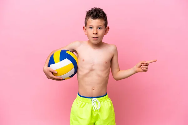Little Caucasian Boy Playing Volleyball Isolated Pink Background Surprised Pointing —  Fotos de Stock