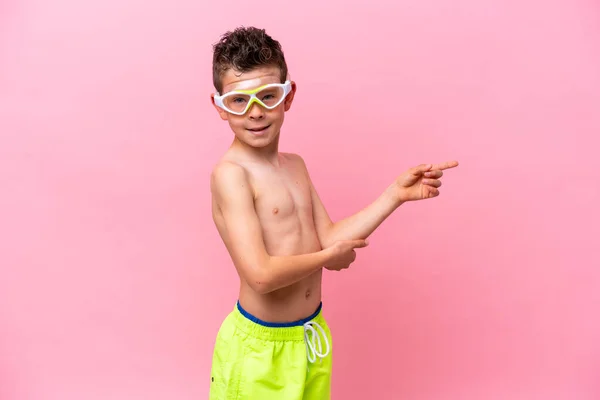 Little Caucasian Boy Wearing Diving Goggles Isolated Pink Background Pointing — Φωτογραφία Αρχείου