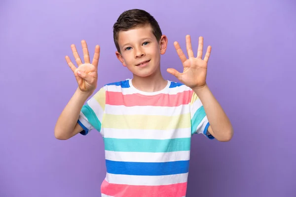 一个被紫色背景隔离的小男孩用手指数着9 — 图库照片