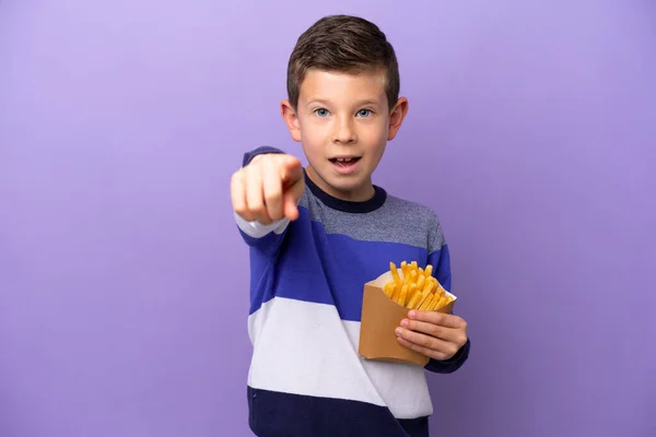 Little Boy Holding Fried Chips Isolated Purple Background Surprised Pointing — Zdjęcie stockowe