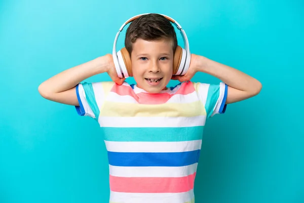 Mały Chłopiec Odizolowany Niebieskim Tle Słuchając Muzyki — Zdjęcie stockowe