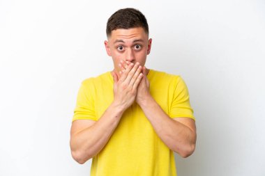Genç Brezilyalı bir adam beyaz arka planda izole edilmiş. Ağzı elleri ile kapatıyor.