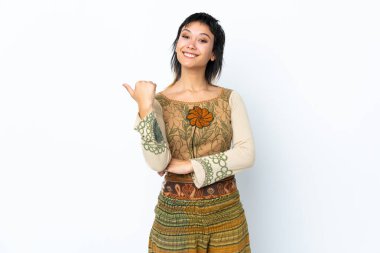 İzole edilmiş beyaz arka planda genç Uruguaylı kız bir ürünü sunmak için kenarı işaret ediyor.