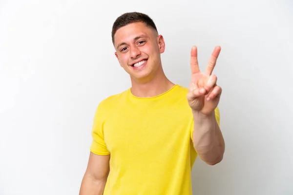 Młody Brazylijczyk Odizolowany Białym Tle Uśmiecha Się Pokazuje Znak Zwycięstwa — Zdjęcie stockowe