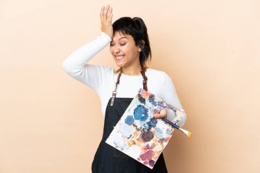 Soyutlanmış arka planda palet tutan genç bir sanatçı, kafa karıştırıcı yüz ifadesi ile ilgili şüpheleri var.