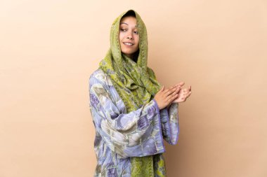 Indian woman isolated on beige background applauding
