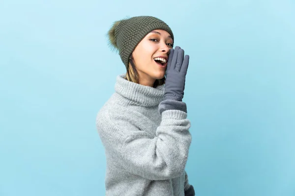 Giovane Ragazza Uruguaiana Con Cappello Invernale Isolato Sfondo Blu Sussurrando — Foto Stock