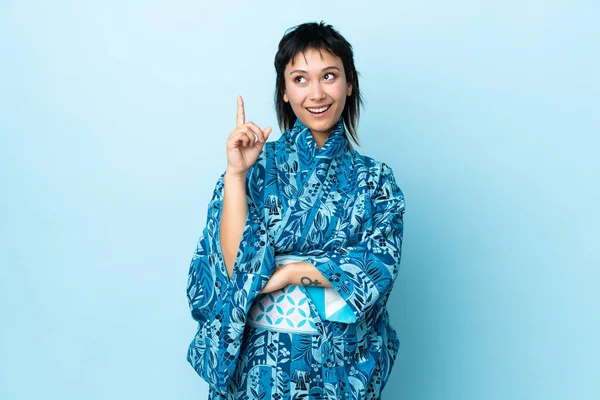 Mujer Joven Usando Kimono Sobre Fondo Azul Aislado Apuntando Una —  Fotos de Stock
