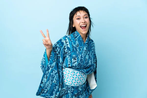 Mujer Joven Usando Kimono Sobre Fondo Azul Aislado Sonriendo Mostrando —  Fotos de Stock