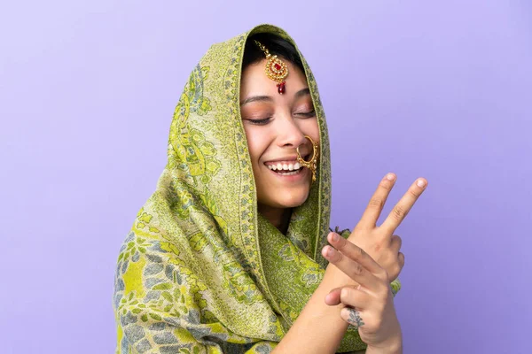 紫の背景に孤立したインドの女性笑顔と勝利の兆候を示す — ストック写真