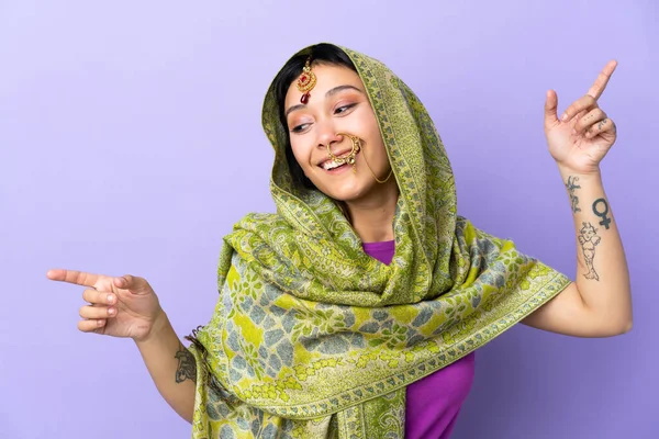 Indian Woman Isolated Purple Background Pointing Finger Laterals Happy — Stock fotografie