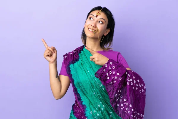 インデックスの指で指差す紫色の背景に隔離されたインドの女性素晴らしいアイデア — ストック写真