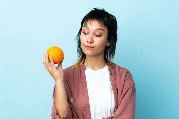 Ung Uruguayansk Kvinna Över Isolerad Blå Bakgrund Håller Orange — Stockfoto