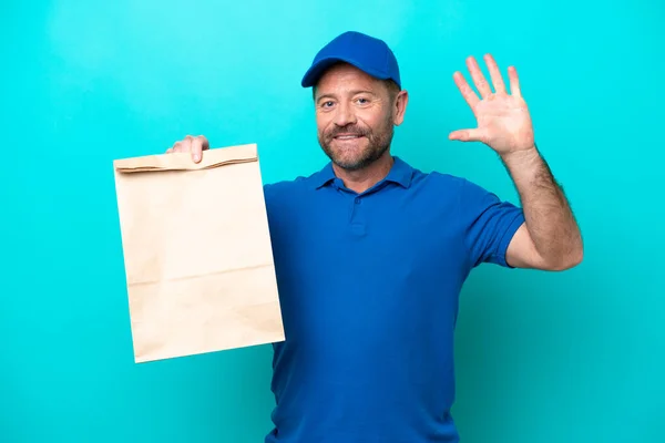 Middelbare Leeftijd Man Neemt Een Zak Afhaalvoedsel Geïsoleerd Blauwe Achtergrond — Stockfoto