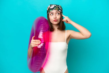 Mavi arka planda hava yatağı tutan genç Ukraynalı kadının şüpheleri ve düşünceleri var.