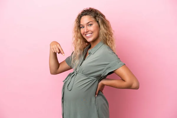 Dziewczyna Kręconymi Włosami Izolowane Różowym Tle Ciąży Wskazując Brzuch — Zdjęcie stockowe