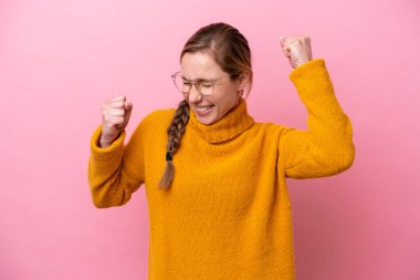 Pembe arka planda izole edilmiş beyaz bir kadın zaferi kutluyor.